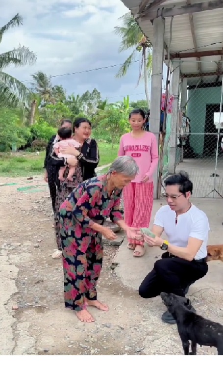 Ngọc Sơn trao tiền cho cụ bà